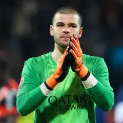 Bramkarz PSG w zielonej koszulce z pomarańczowymi rękawicami, z dłońmi złożonymi do oklasków.