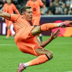 Piłkarz w pomarańczowym stroju wykonuje przewrotkę, celując w piłkę. Czy to on gra w finale Ligi Mistrzów?