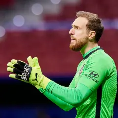 Bramkarz Jan Oblak w zielonej koszulce z rękawicami, gotowy do obrony.