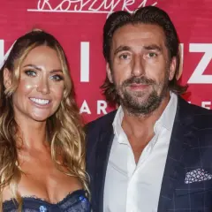 Tomasz Iwan z pierwszą żoną, uśmiechnięci na tle czerwonej ścianki z napisem "Koszyki".
