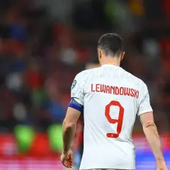 Piłkarz Robert Lewandowski w białej koszulce z czerwonym napisem "LEWANDOWSKI" i numerem 9.