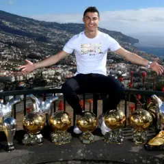 Cristiano Ronaldo z dumą prezentuje swoje liczne trofea, w tym Złote Piłki, na tle malowniczego krajobrazu Madery, swojego rodzinnego domu.