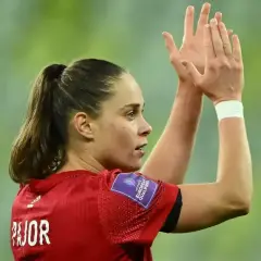 Piłkarka Ewa Pajor, z włosami spiętymi w kucyk, klaszcze w dłonie. Na jej ramieniu widnieje naszywka "Women's European Qualifiers".