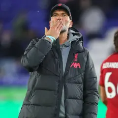 Trener Liverpoolu, Jürgen Klopp, posyła całusa kibicom. Obok niego stoi piłkarz z numerem 66.