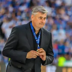 Maciej Skorża, po wygranej, trzyma medal. W tle tłum kibiców. Jego żona wspierała go w walce z chorobą.