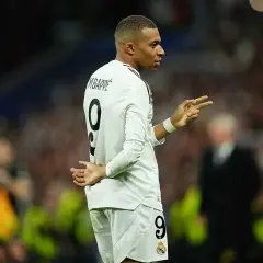 Mbappé w białej koszulce z numerem 9, gestykuluje, jakby świętował urodziny.