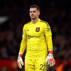 Tom Heaton, bramkarz Manchesteru United, w żółtym stroju bramkarskim, z rękawicami i numerem 22 na spodenkach.