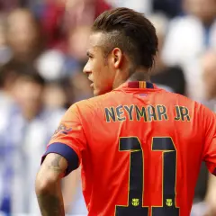 Neymar w Barcelonie, w pomarańczowej koszulce z numerem 11, na tle trybun.