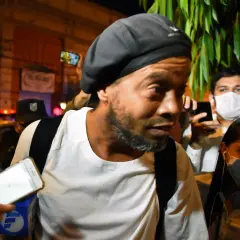 Ronaldinho w otoczeniu policji i tłumu, z telefonami skierowanymi na niego. Słynny piłkarz, którego losy potoczyły się w nieoczekiwany sposób, w tym do więzienia.