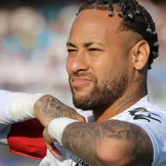 Neymar, z charakterystycznymi warkoczykami i tatuażami, w białej koszulce. Jego majątek budowany jest na boisku i poza nim.
