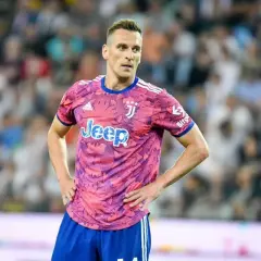 Piłkarz Arkadiusz Milik w różowej koszulce Juventusu z logo Jeep.