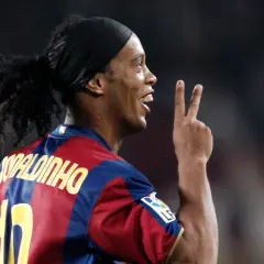 Ronaldinho w barwach FC Barcelony, klubu, w którym grał wiele lat. Pokazuje dwa palce, symbolizując zwycięstwo.