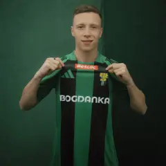 Młody piłkarz, którego miszor wiek sugeruje, że jest na początku kariery, prezentuje zielono-czarną koszulkę z logo Bogdanka.