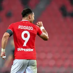 Piłkarz Rodado z numerem 9 świętuje bramkę. Jego koszulka z napisem SUPERBET i logo I Ligi Statystyki świadczy o jego sukcesach.