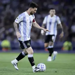 Lionel Messi w koszulce Argentyny drybluje z piłką. Jego wzrost nie przeszkadza mu w byciu jednym z najlepszych piłkarzy świata.