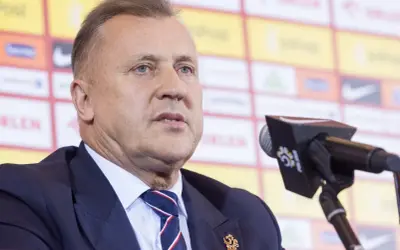 Cezary Kulesza, prezes PZPN, w garniturze i krawacie, z mikrofonem przed sobą. Jego majątek budzi zainteresowanie.
