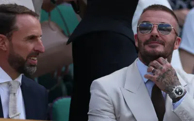 David Beckham, którego majątek robi wrażenie, w okularach przeciwsłonecznych i eleganckim jasnym garniturze, rozmawia z Garethem Southgate'em.