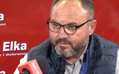 Piotr Rusiecki w kamizelce i okularach udziela wywiadu w Radiu Elka. Może opowiada o swojej żonie.