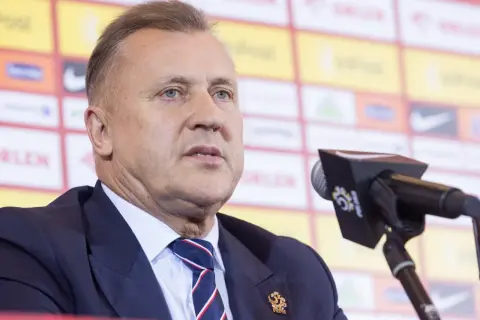 Cezary Kulesza, prezes PZPN, w garniturze i krawacie, z mikrofonem przed sobą. Jego majątek budzi zainteresowanie.