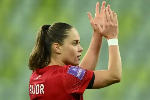 Piłkarka Ewa Pajor, z włosami spiętymi w kucyk, klaszcze w dłonie. Na jej ramieniu widnieje naszywka "Women's European Qualifiers".