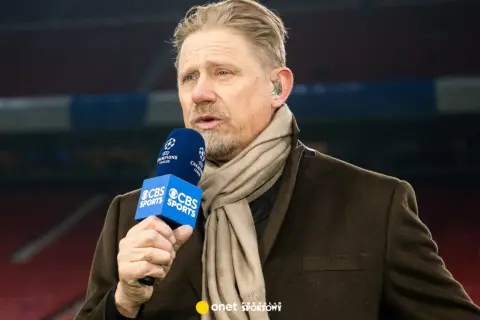 Antoni Schmeichel, z mikrofonem CBS Sports i szalikiem, komentuje mecz Ligi Mistrzów.