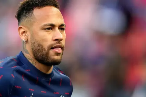 Neymar w charakterystycznych fryzurach, z kolczykami i tatuażami, w granatowej bluzie z napisem "PARIS".