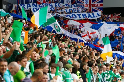 Tłum kibiców z flagami Irlandii i Wielkiej Brytanii. W tle transparenty z napisem "RANGERS". To lokalny rywal piłkarzy Glasgow Rangers.