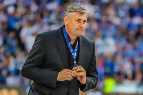 Maciej Skorża, po wygranej, trzyma medal. W tle tłum kibiców. Jego żona wspierała go w walce z chorobą.