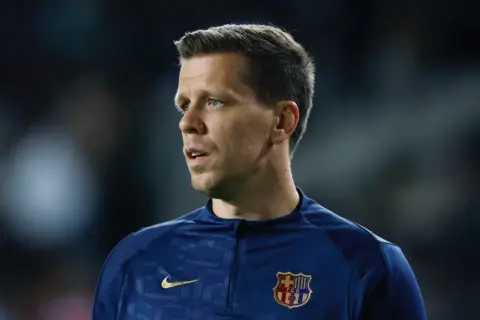 Bramkarz FC Barcelona w granatowej bluzie treningowej z herbem klubu.