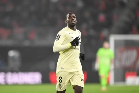 Piłkarz w żółtej koszulce z numerem 8, gdzie gra Pogba, biegnie po boisku w deszczu.