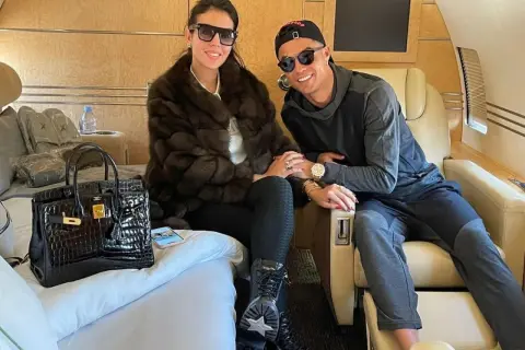 Para w luksusowym samolocie, symbol majątku Ronaldo. Georgina w futrze, Cristiano w czapce, oboje w okularach.