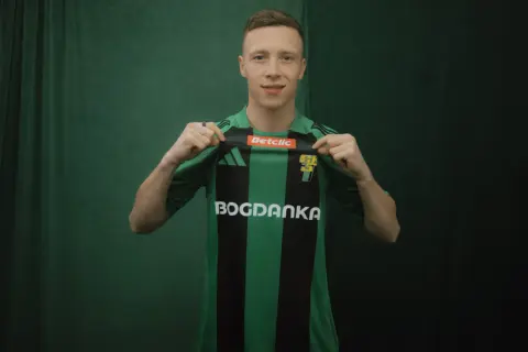 Młody piłkarz, którego miszor wiek sugeruje, że jest na początku kariery, prezentuje zielono-czarną koszulkę z logo Bogdanka.
