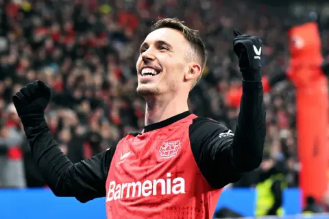 Piłkarz świętuje, podnosząc ręce. Jego radość sugeruje, że jest jednym z najlepszych lewych obrońców.