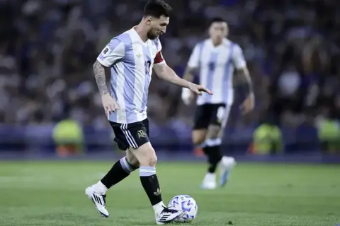 Lionel Messi w koszulce Argentyny drybluje z piłką. Jego wzrost nie przeszkadza mu w byciu jednym z najlepszych piłkarzy świata.