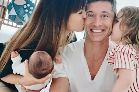 Anna Lewandowska całuje Roberta, a ich córki, Klara i Laura, również okazują mu miłość.