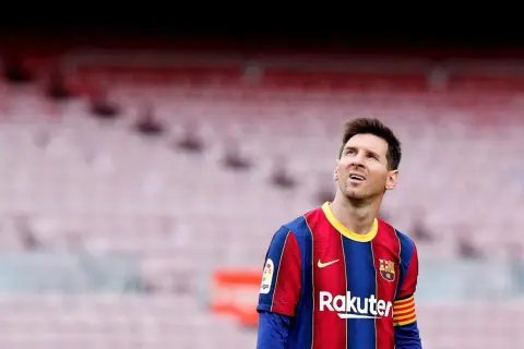 Messi w Barcelonie, w swoim charakterystycznym stroju, spogląda w górę na trybuny stadionu.