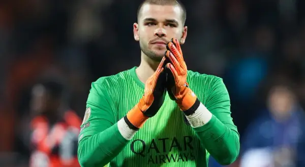 Bramkarz PSG w zielonej koszulce z pomarańczowymi rękawicami, z dłońmi złożonymi do oklasków.