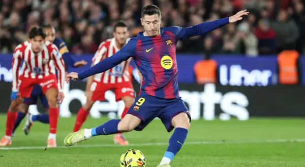 Robert Lewandowski wykonuje rzut karny, celując w bramkę przeciwnika.