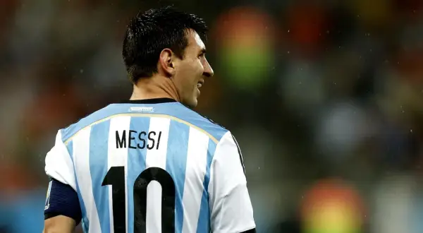 Widok z tyłu na Leo Messiego w koszulce Argentyny z numerem 10. Widać jego profil i uśmiech.