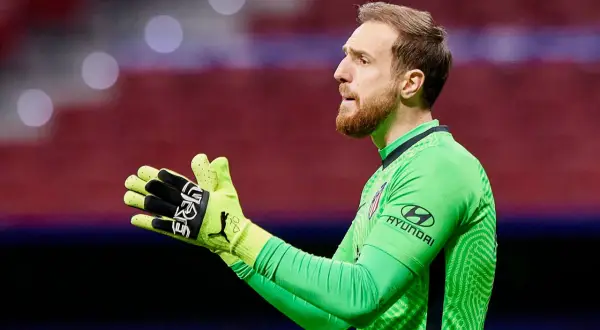 Bramkarz Jan Oblak w zielonej koszulce z rękawicami, gotowy do obrony.
