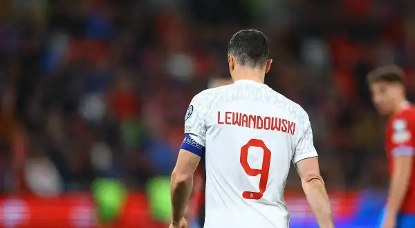 Piłkarz Robert Lewandowski w białej koszulce z czerwonym napisem "LEWANDOWSKI" i numerem 9.