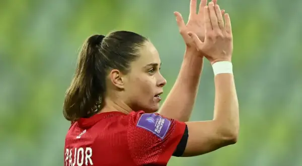 Piłkarka Ewa Pajor, z włosami spiętymi w kucyk, klaszcze w dłonie. Na jej ramieniu widnieje naszywka "Women's European Qualifiers".