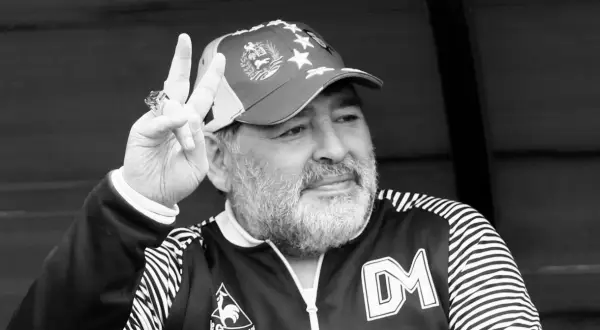 Diego Maradona, w czapce z gwiazdami, pokazuje znak pokoju. Ile lat ma Maradona? Tego nie wiemy, ale jego charyzma jest wieczna.