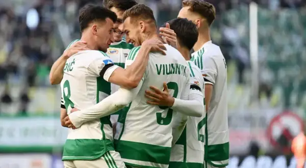 Piłkarze z Gdańska świętują bramkę. Radosne objęcia na boisku po udanej akcji.