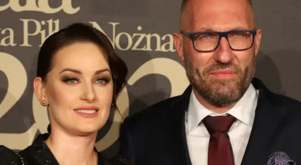 Marek Papszun z pierwszą żoną, uśmiechnięci, pozują do zdjęcia na tle napisu.