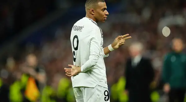 Mbappé w białej koszulce z numerem 9, gestykuluje, jakby świętował urodziny.