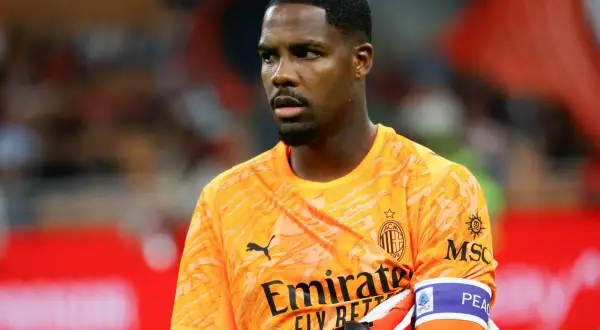 Bramkarz Francji, Mike Maignan, w pomarańczowej koszulce AC Milan, gotowy do obrony.