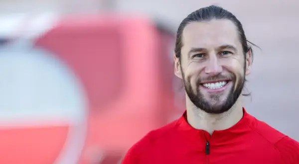 Uśmiechnięty Grzegorz Krychowiak w czerwonej bluzie reprezentacji Polski. Jego wiek to doświadczenie na boisku.