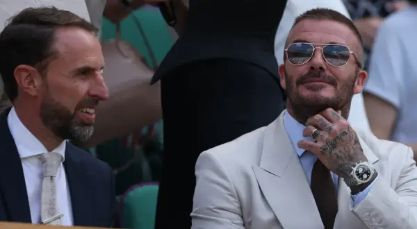 David Beckham, którego majątek robi wrażenie, w okularach przeciwsłonecznych i eleganckim jasnym garniturze, rozmawia z Garethem Southgate'em.