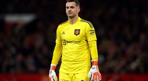 Tom Heaton, bramkarz Manchesteru United, w żółtym stroju bramkarskim, z rękawicami i numerem 22 na spodenkach.